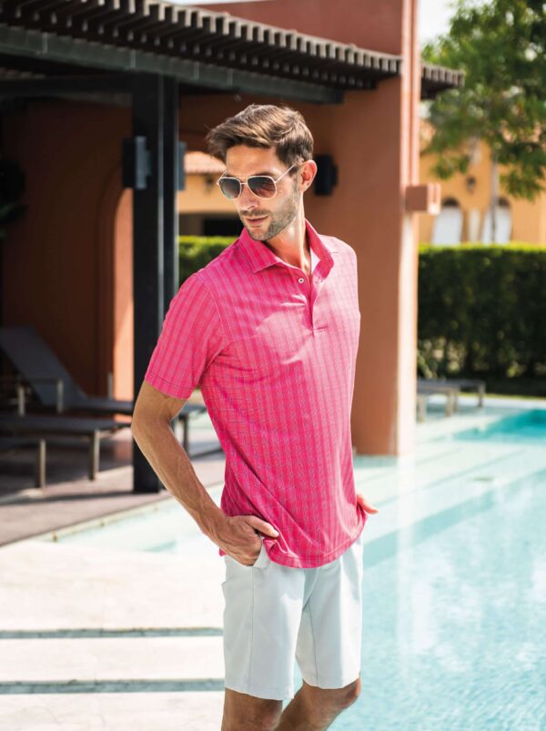 Model posing by swimming pool wearing pink ponce de leon Fenix XCell PE polo shirt